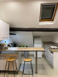 a kitchen with a wooden table and two stools at Les Loges de la Commanderie ! in Coulommiers