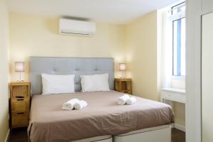 a bedroom with a bed with two towels on it at GuestReady - An amazing blue ocean view in Funchal