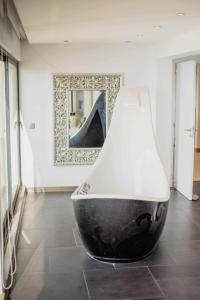 een zwart-witte vaas in een kamer met een spiegel bij Zula House - Stunning designer villa in spectacular location in Caniço