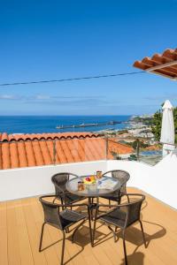 d'une table et de chaises sur un balcon avec vue sur l'océan. dans l'établissement GuestReady - An amazing blue ocean view, à Funchal