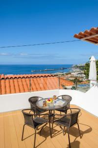a table and chairs on a balcony with a view of the ocean at GuestReady - An amazing blue ocean view in Funchal