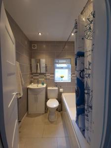 La salle de bains est pourvue de toilettes, d'un lavabo et d'une baignoire. dans l'établissement Gorgeous Edwardian Terrace in Old Trafford, à Manchester