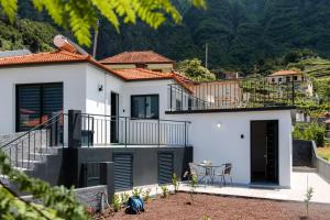 a white house with a balcony and a table at GuestReady - Panoramic Mountain Escape in São Vicente