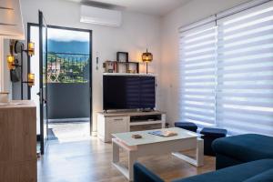 sala de estar con TV, sofá y mesa en GuestReady - Panoramic Mountain Escape en São Vicente