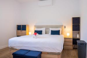 a bedroom with a large white bed with blue pillows at GuestReady - Panoramic Mountain Escape in São Vicente