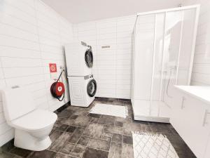 a bathroom with a toilet and a washing machine at Destination Senja - Skaland in Skaland