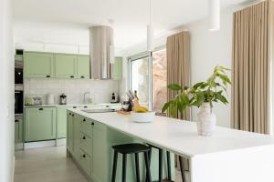 a kitchen with green cabinets and a white counter top at GuestReady - A delightful stay in Porto Santo in Campo de Baixo