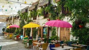 a patio with tables and umbrellas in front of a building at Sherryflat C/Larga in Jerez de la Frontera