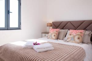 1 dormitorio con 1 cama con toallas en GuestReady - Quiet house & heated pool w sea view, en Prazeres