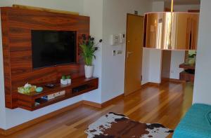a living room with a flat screen tv on a wall at Condomínio Zen Pearl-Luxury com piscina in Funchal