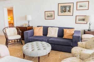 a living room with a blue couch and chairs at Vila da Falésia-With Pool and views in Caniço