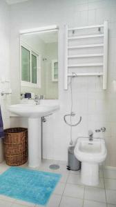 W łazience znajduje się umywalka, toaleta i lustro. w obiekcie Vila da Falésia-With Pool and views w Caniço