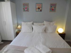 duże białe łóżko z białymi poduszkami w obiekcie Barreirinha I-Near Cidade Velha, Vista de Ocean w Funchal