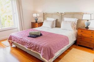 a bedroom with a large bed with a pink blanket at Vila da Falésia-With Pool and views in Caniço