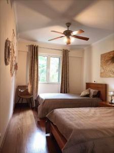 a bedroom with two beds and a ceiling fan at GuestReady - Vila Formosa in Funchal