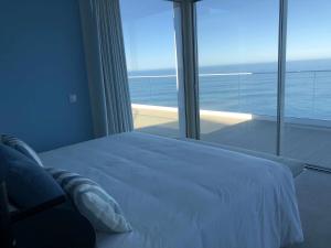 - une chambre avec un lit blanc et une grande fenêtre dans l'établissement Casa Del Mar - Vistas Maravilhosas do Mar e Piscina, à Ponta Delgada