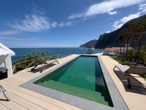 a swimming pool on a deck with a view of the ocean at Casa Del Mar - Vistas Maravilhosas do Mar e Piscina in Ponta Delgada