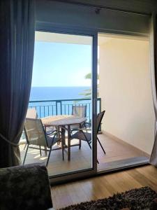 a balcony with a table and chairs and the ocean at GuestReady - Vila Formosa in Funchal