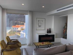 a living room with a couch and chairs and a fireplace at Casa Del Mar - Vistas Maravilhosas do Mar e Piscina in Ponta Delgada