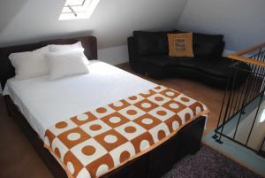 een slaapkamer met een bed en een bank bij Vila Rosa - Renovated House Overlooking The Sea in Funchal