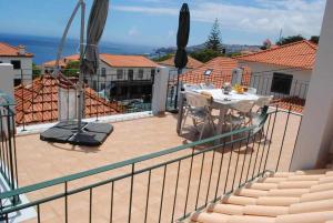 Il dispose d'une terrasse avec une table et des chaises. dans l'établissement Vila Rosa - Renovated House Overlooking The Sea, à Funchal