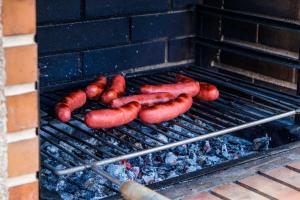 a bunch of sausages cooking on a grill at Windmill House- Near beach in Porto Santo
