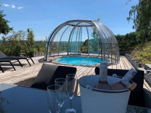 una bottiglia di vino seduta su un tavolo accanto alla piscina di Ferienhaus mit Privatpool für 4 Personen ca 120 qm in Trois-Ponts, Wallonie Spa-Francorchamps und Umgebung a Trois-Ponts