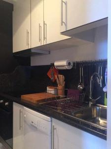 een keuken met witte kasten, een wastafel en een aanrecht bij Lido Mar - Hotels area in Funchal