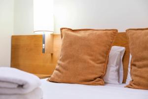 a bed with two pillows and a lamp on it at Garajau Terrace - Amazing Views of Garajau Town in Garajau