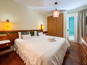1 dormitorio con 1 cama blanca grande y 2 almohadas en Garajau Terrace - Amazing Views of Garajau Town, en Garajau
