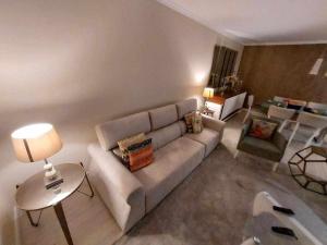 a living room with a white couch and a table at GuestReady - Nora Premium in Santa Luzia