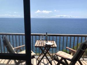 a table and chairs on a balcony with the ocean at Cliff View III - Sea View + Pool + Wifi in Ilhéu do Gorgulho