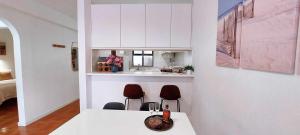 a kitchen with a table and two chairs in a room at Madeira - Sunset Sea View of Cabo Girão in Panasqueira