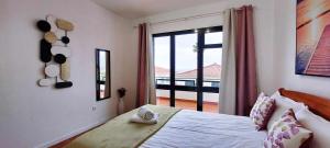 a bedroom with a bed and a large window at Madeira - Sunset Sea View of Cabo Girão in Panasqueira +11 photos