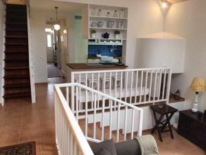 a living room with a staircase and a kitchen at GuestReady - Casa Avó Alice in Porto da Cruz