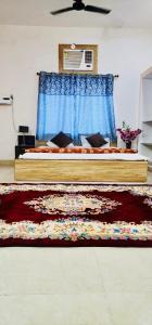 1 dormitorio con 1 cama con cortina azul y alfombra en Grand Hotel Inn, en Gaya