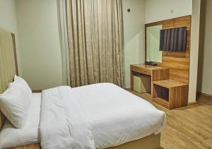 Dormitorio con cama, escritorio y TV en غرف فندقية هارودز, en Yeda