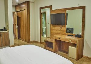 Habitación de hotel con cama y TV en غرف فندقية هارودز, en Yeda