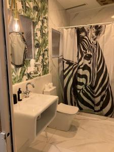 baño con cortina de ducha de cebra y lavamanos en Natura LifeStyle gran Vía, en Madrid