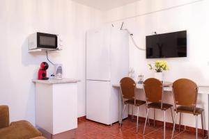 cocina con nevera blanca, mesa y sillas en GuestReady - Machico sea view residence - B en Machico