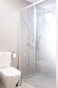 y baño blanco con ducha y aseo. en GuestReady - Machico sea view residence - B, en Machico