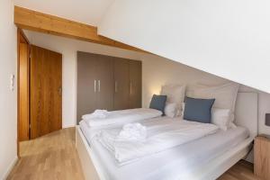 1 cama grande con sábanas blancas y almohadas azules en Lautertal Loft en Blaustein