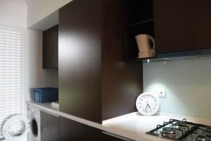 a kitchen with a stove and a clock on a counter at GuestReady - Tamariz Cosy Stay in Caniço
