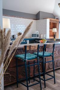 een keuken met een aanrecht met twee blauwe barkrukken bij GuestReady - A marvellous stay in Calheta in Calheta