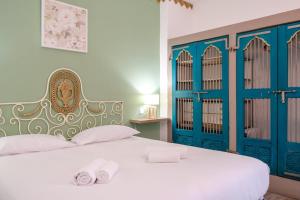 1 dormitorio con 1 cama con puertas azules y toallas en GuestReady - A marvellous stay in Calheta, en Calheta