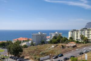 een stad met een snelweg en gebouwen en de oceaan bij GuestReady - Scenic Retreat with Seaview in Funchal
