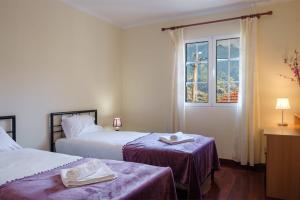 サン・ヴィセンテにあるGuestReady - Tranquil Spot in São Vicenteのベッド2台と窓が備わるホテルルームです。