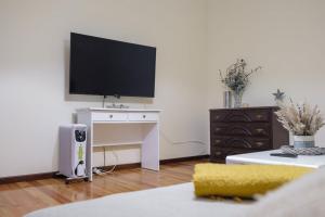 een woonkamer met een bureau en een televisie. bij GuestReady - Tranquil Spot in São Vicente in São Vicente