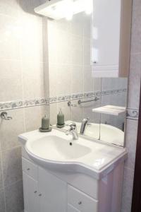 La salle de bains est pourvue d'un lavabo blanc et d'un miroir. dans l'établissement GuestReady - Tranquil Spot in São Vicente, à São Vicente