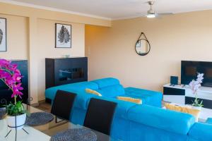 een woonkamer met een blauwe bank en een tafel bij GuestReady - One happy stay in Machico in Santa Cruz